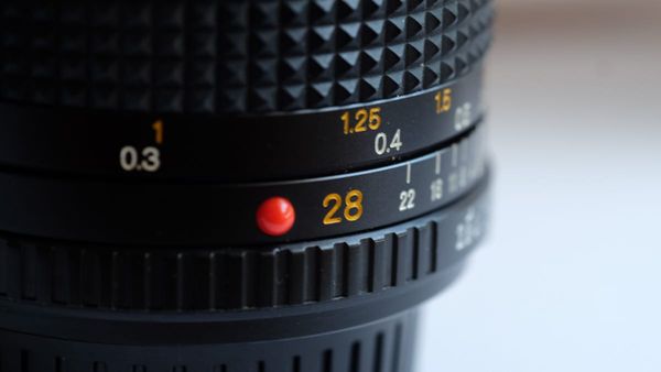 Close up image of a Minolta 28mm MD lens.