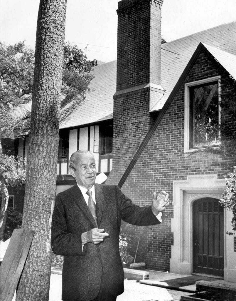 Paul R. Williams standing in front of a brick Tudor-style home. Courtesy of Los Angeles Times.