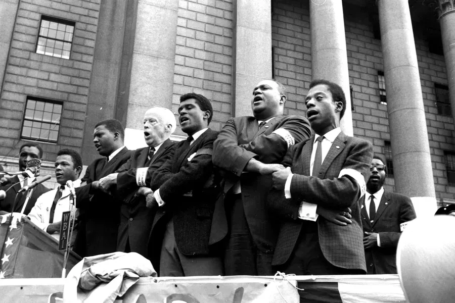 a black and white photo of james baldwin participating in a civil rights movement demonstration