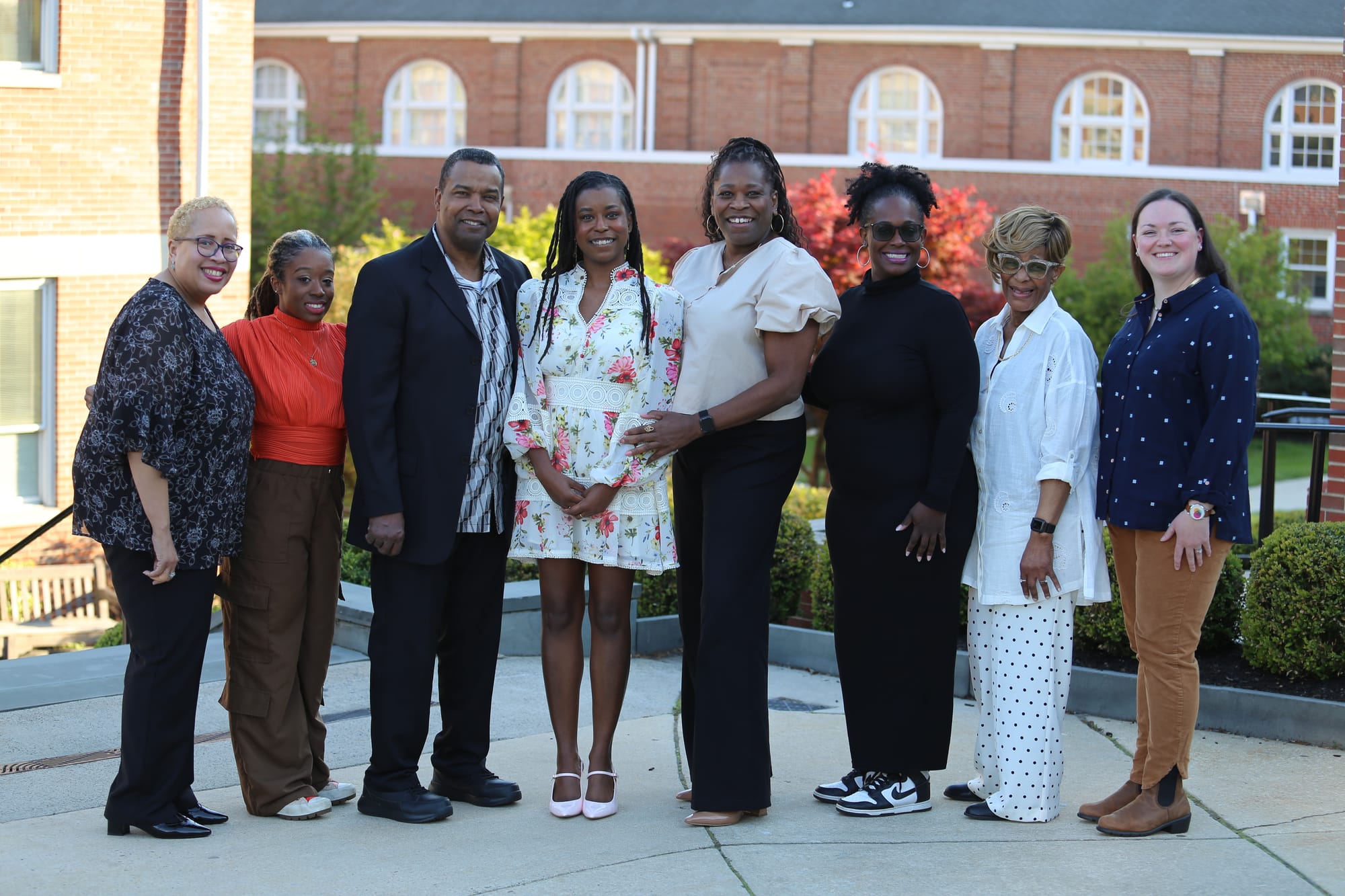 Alleanna Harris, her family, and her classmate Ailsa stand in front of the Moorestown Friends School campus.