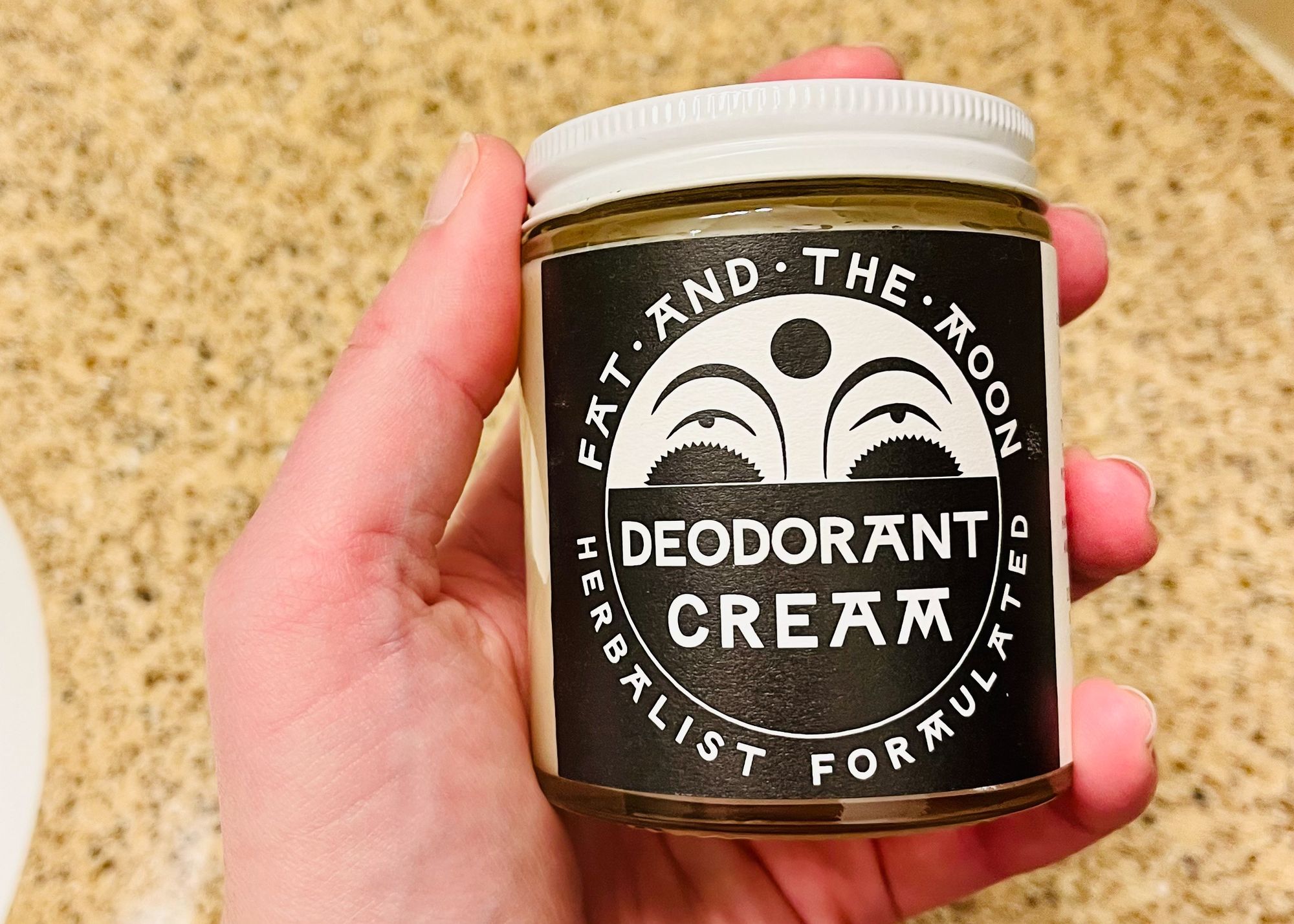 Me holding a large jar of Fat & the Moon Deodorant Cream