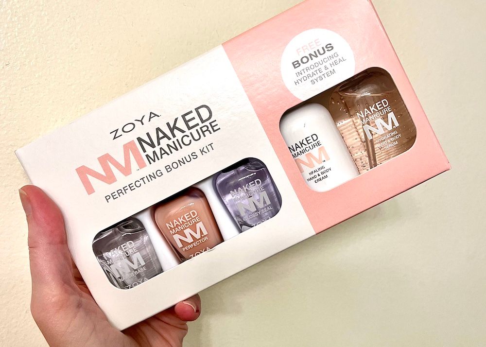 Me holding the Zoya Naked Manicure Perfecting Bonus Kit, with base coat, perfector, top coat, and bonus serum and hand cream.