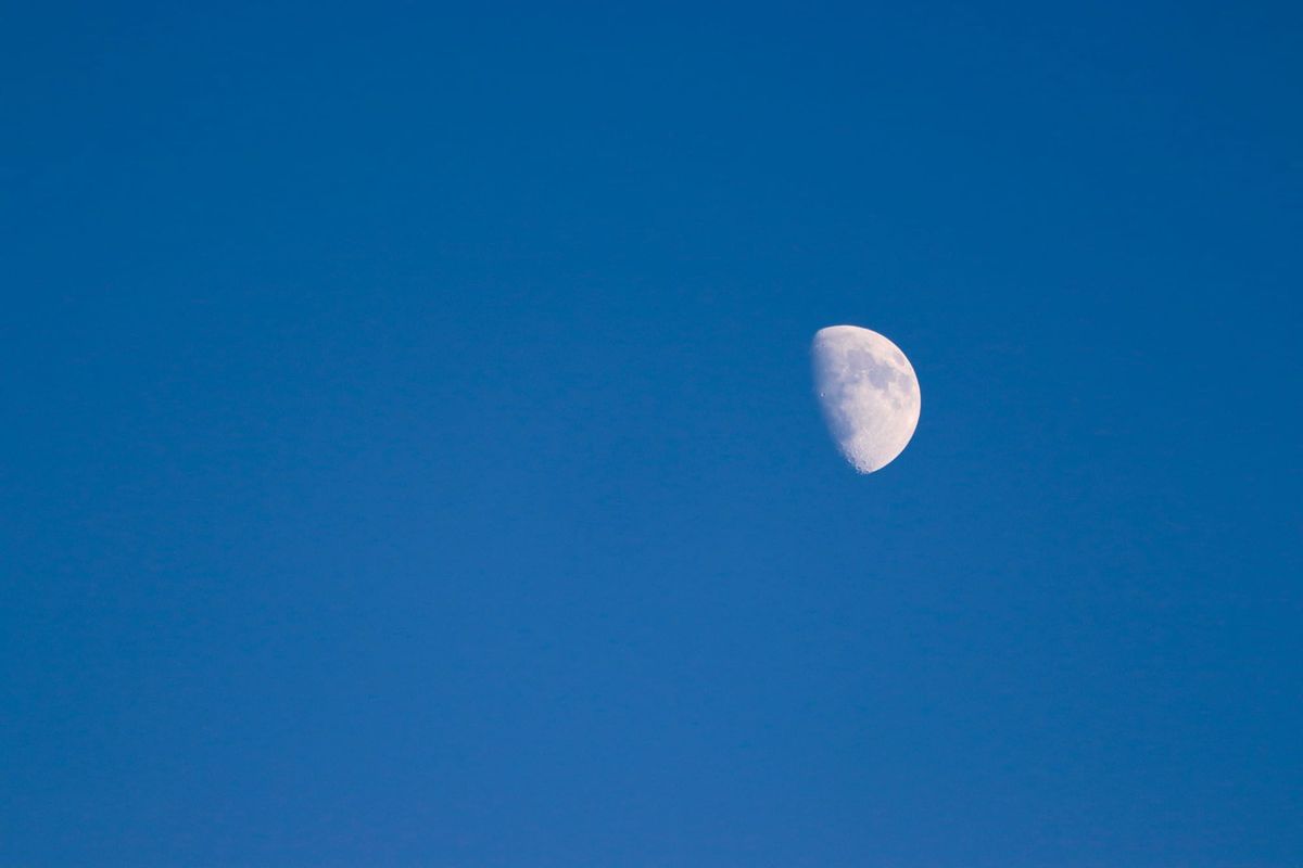 A waxing moon in a clear blue sky