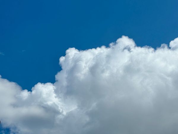 A bright blue sky with fluffy white clouds
