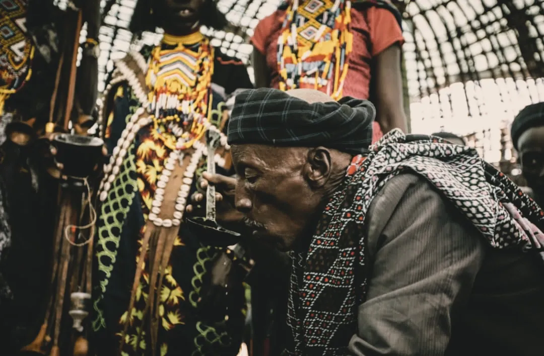 A respected elder partakes in the sacred Buna Kela ceremony. Among the Oromo, elders guide the ritual with calm authority, turning coffee into an act of reconciliation and moral teaching.