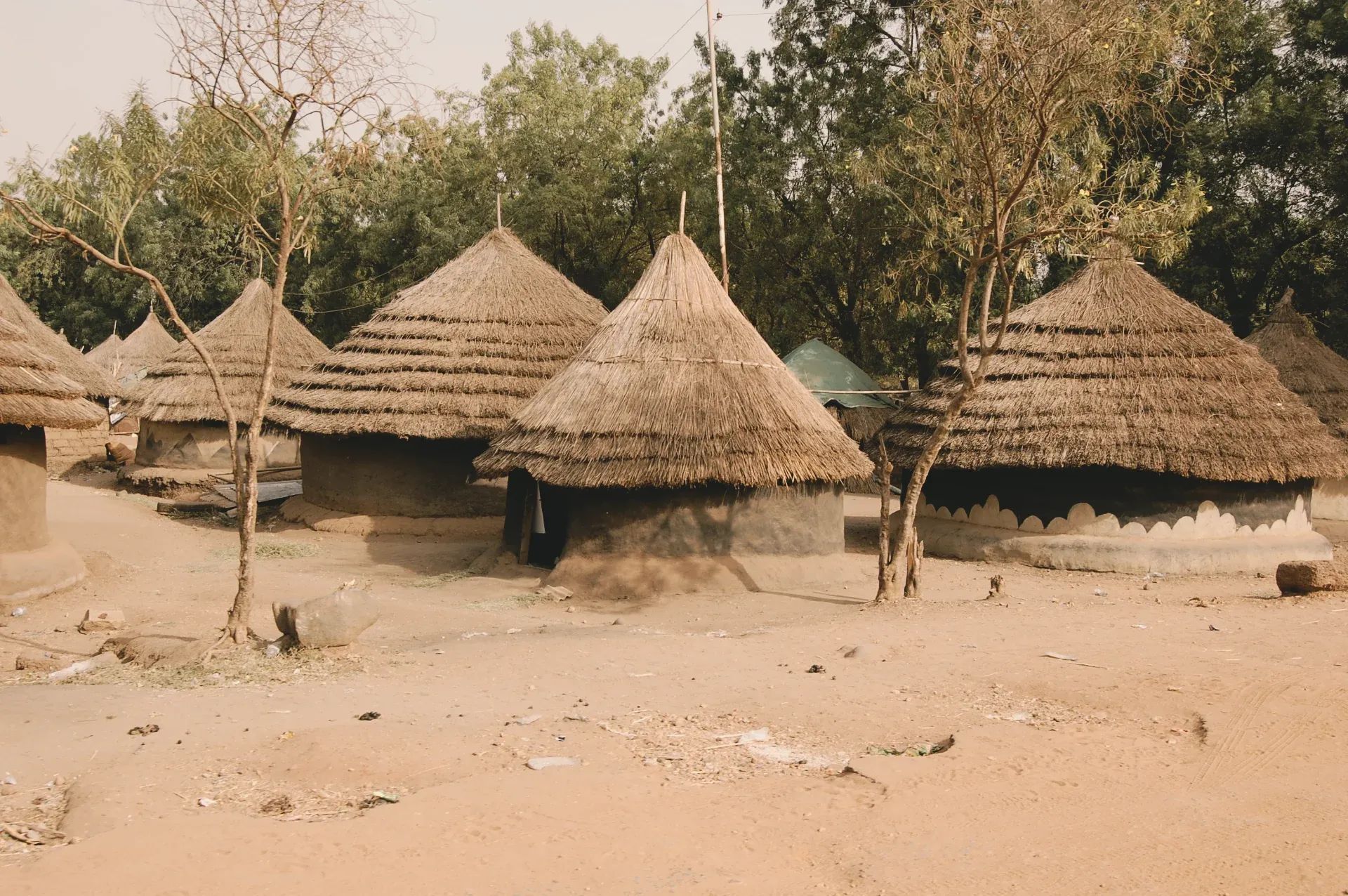 Traditional round huts with thatched roofs in a rural village landscape in South Sudan.