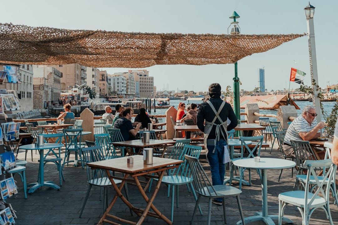 A group of people sitting at tables under an umbrella