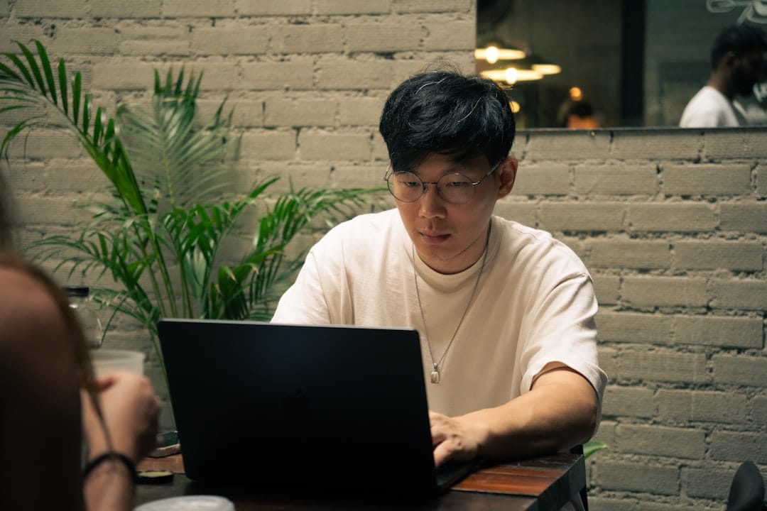 Man works on a laptop at a cafe.