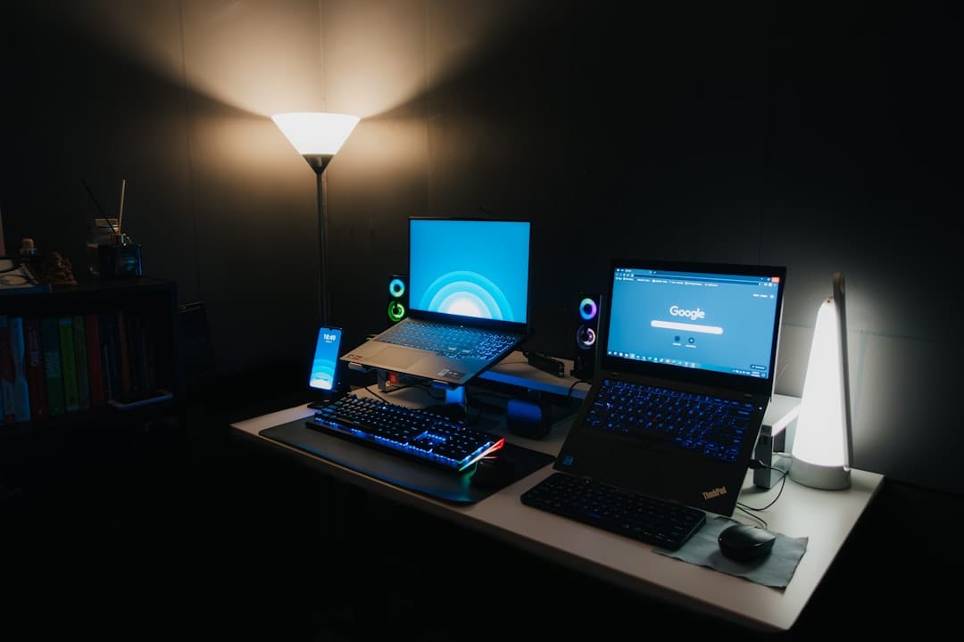 a desk with two laptops, a keyboard and a mouse