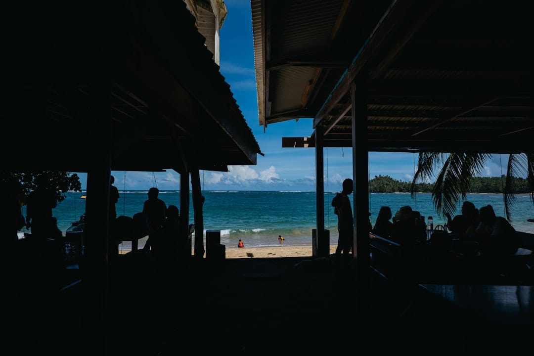 People relaxing at a beachside cafe overlooking the ocean.
