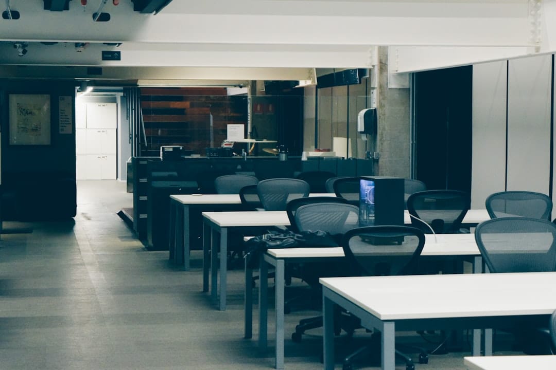 Empty modern office with rows of desks and chairs.
