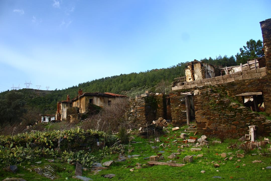 Abandoned stone houses on a grassy hillside