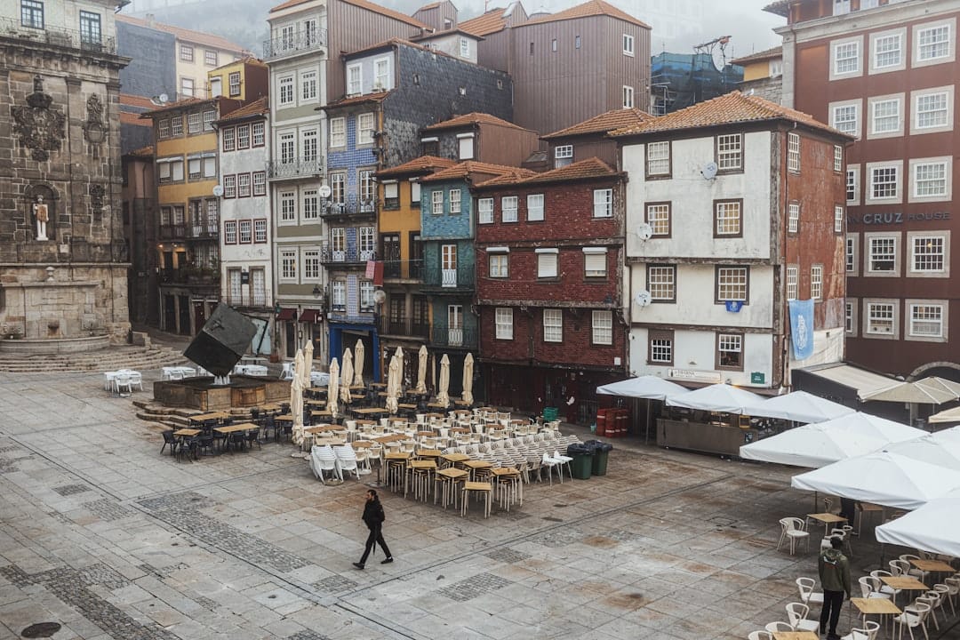 Empty square with outdoor cafe seating and buildings