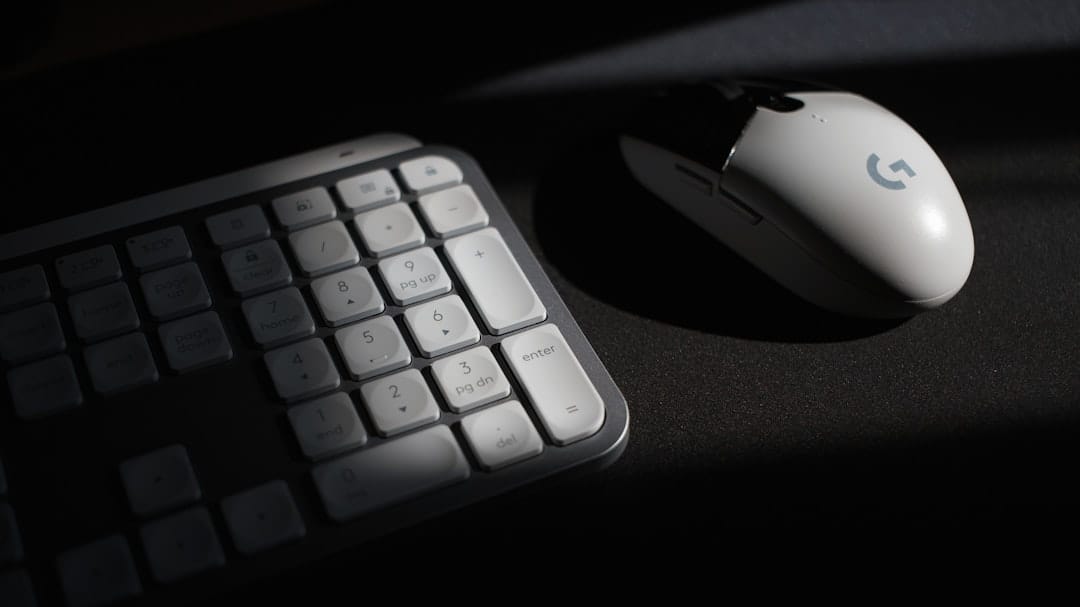 White computer mouse and keyboard in shadow