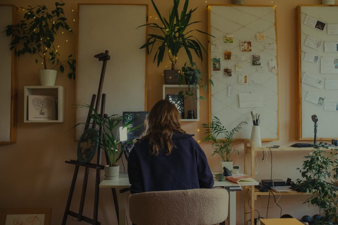 Woman working at a desk in a plant-filled studio