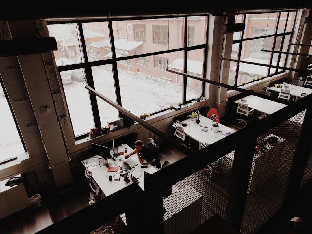 Modern office space with large windows and desks.