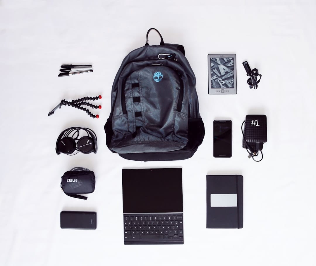 flat lay photography of backpack, laptop computer, headphones, smartphone, and octopus tripod