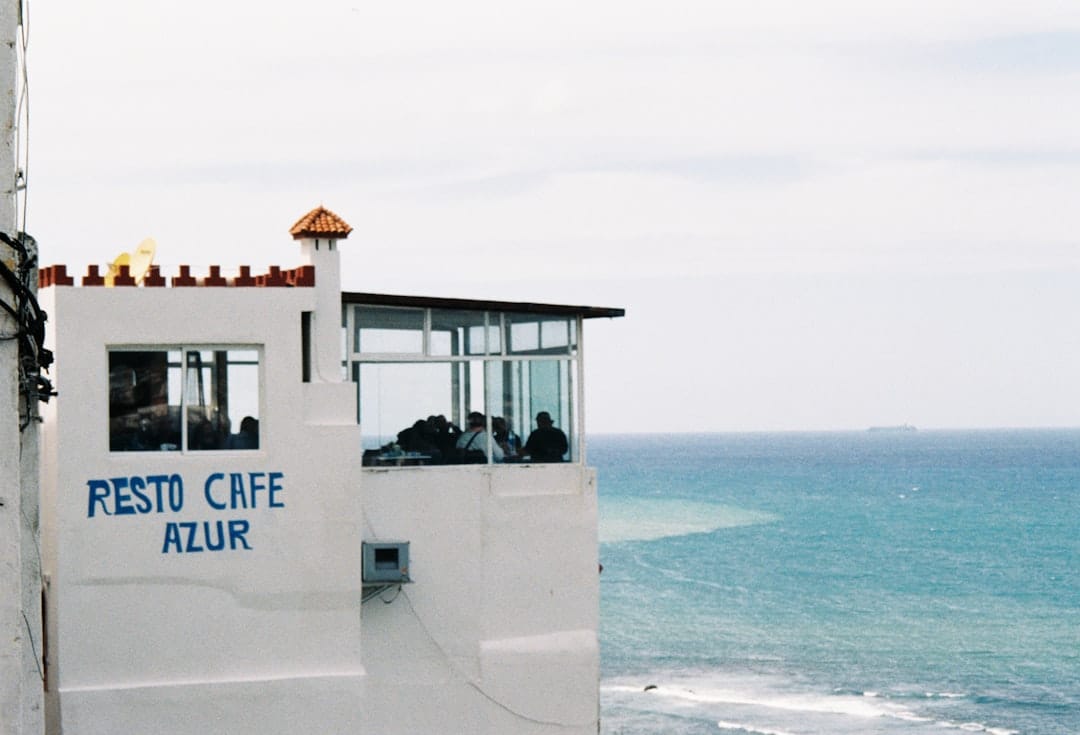 Cafe overlooking the ocean with "resto cafe azur" sign.