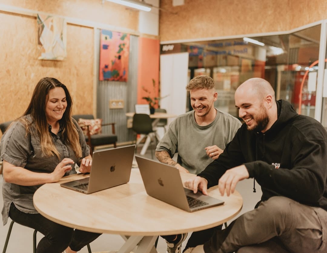 Three people are working and laughing together.