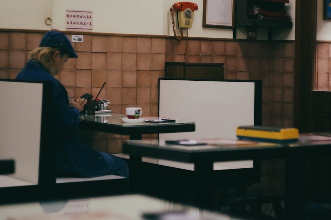 Solitary person in blue sits at a cafe table.