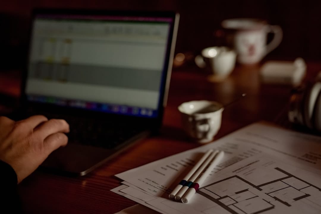a person sitting at a desk with a laptop and papers