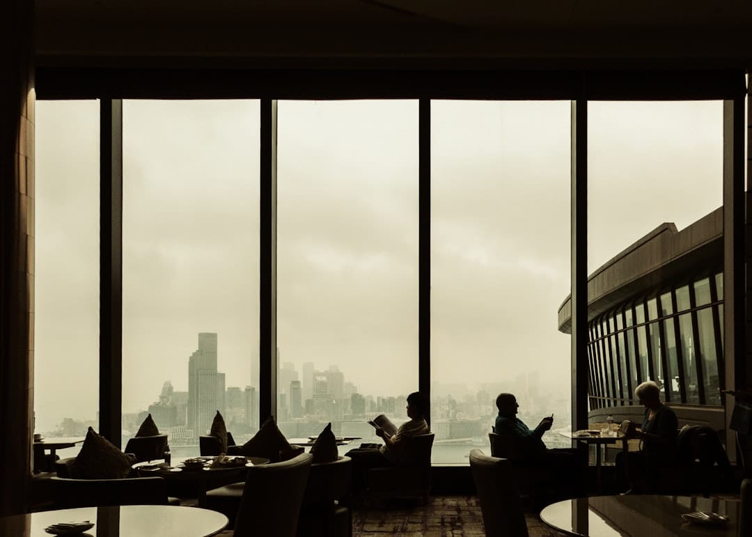 People sit near a window overlooking a cityscape