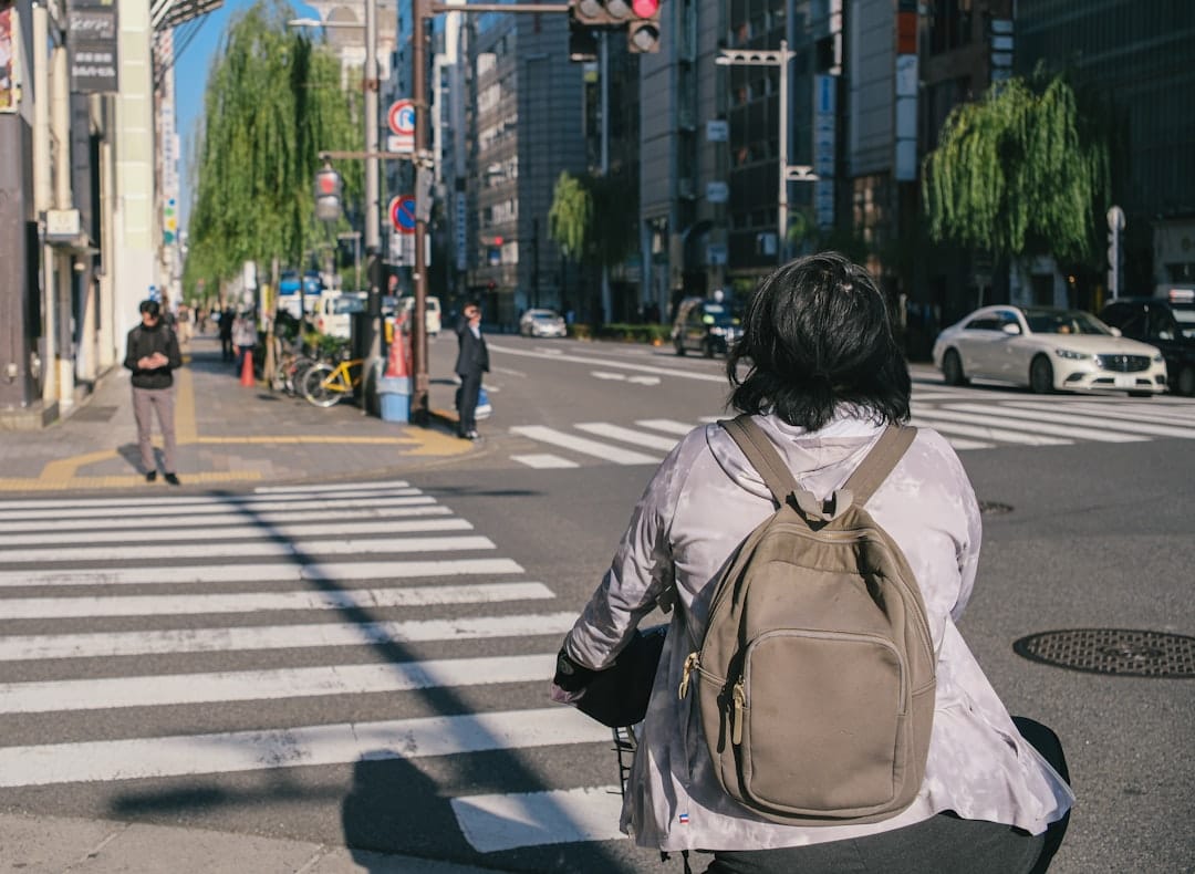 Person with backpack crossing busy city street