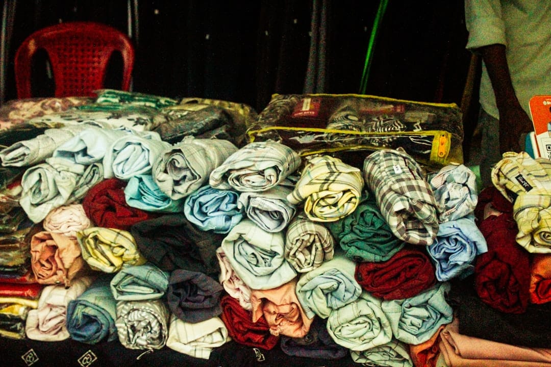 Rolled textiles and clothing displayed at a market stall