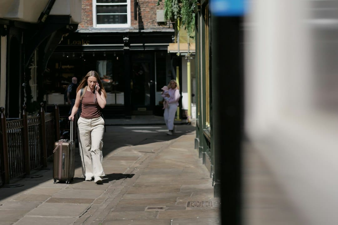 Woman walking with suitcase on cobblestone street