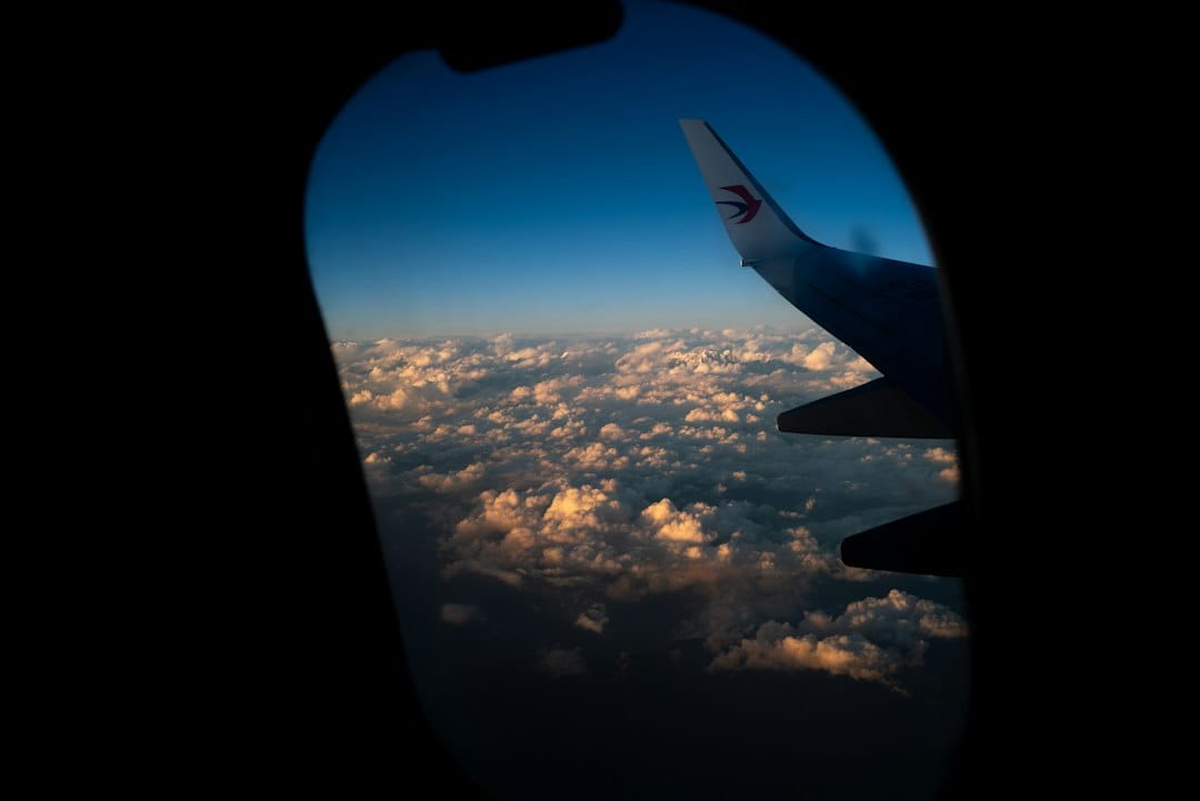 Airplane wing above clouds at sunset