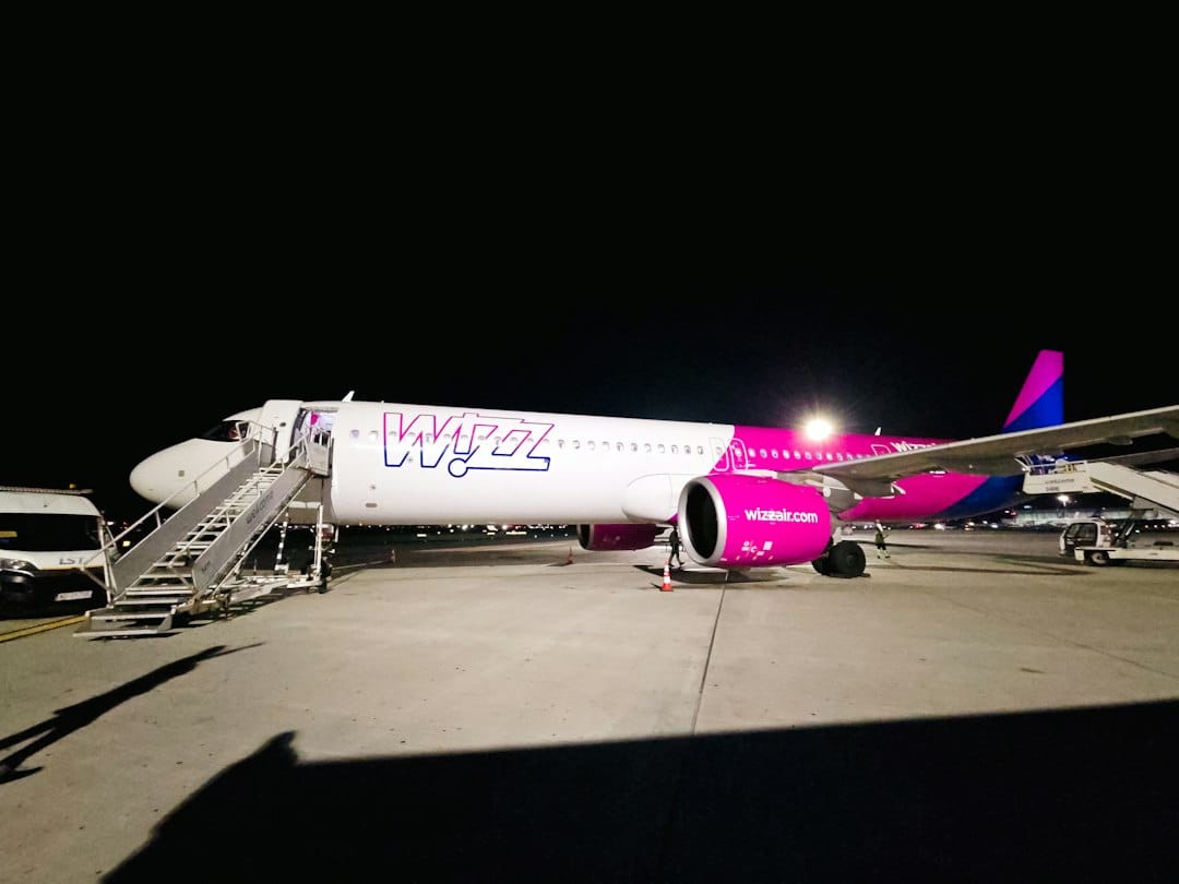 A Wizz Air passenger jet parked on an airport tarmac at night
