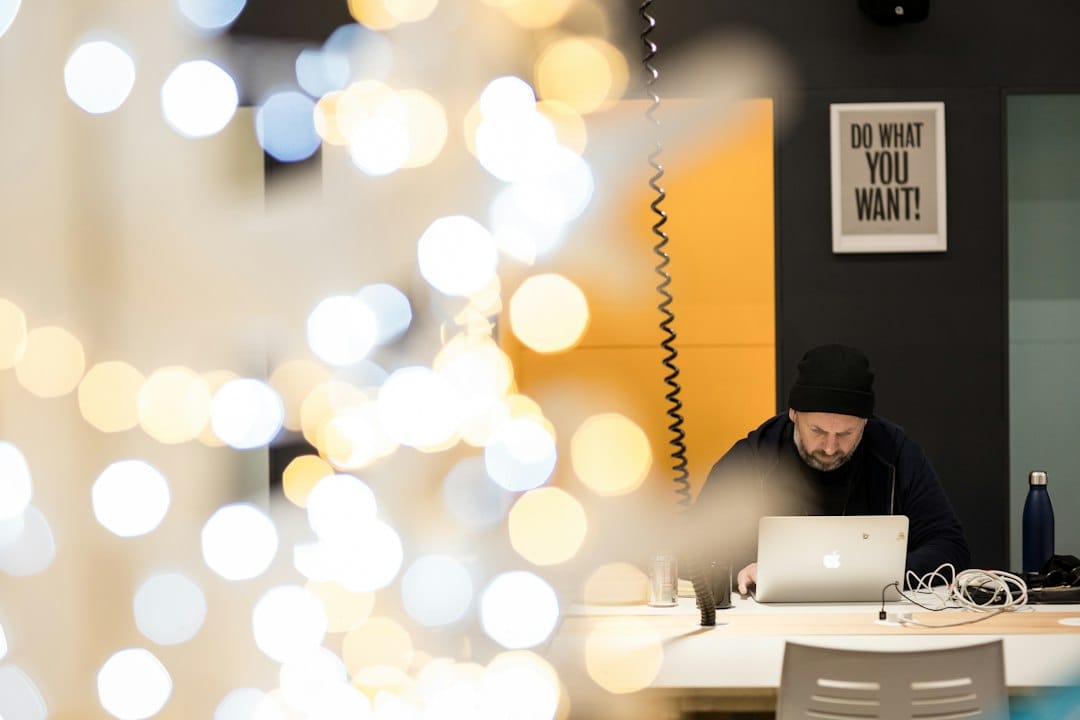 a man sitting at a table working on a laptop