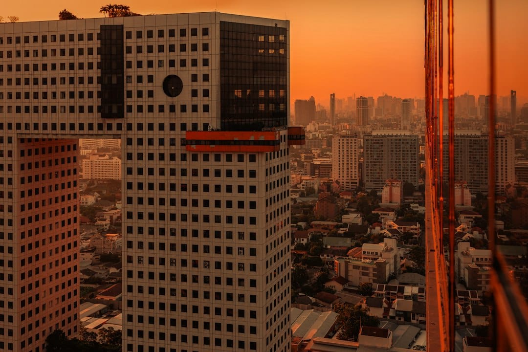 Modern buildings against a vibrant orange sunset sky