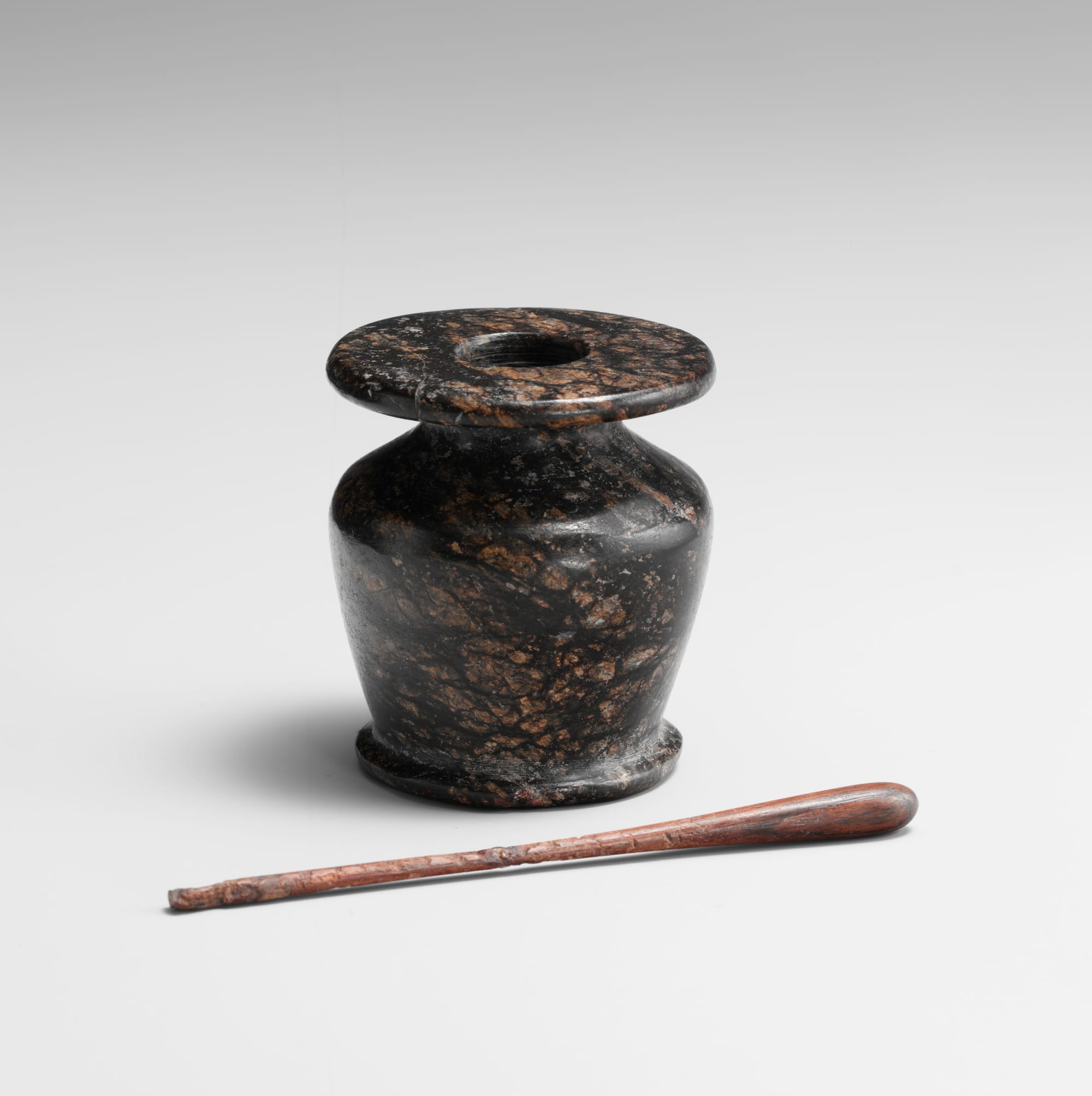 Ancient Egyptian stone cosmetic vessel with applicator, used for ritual and adornment