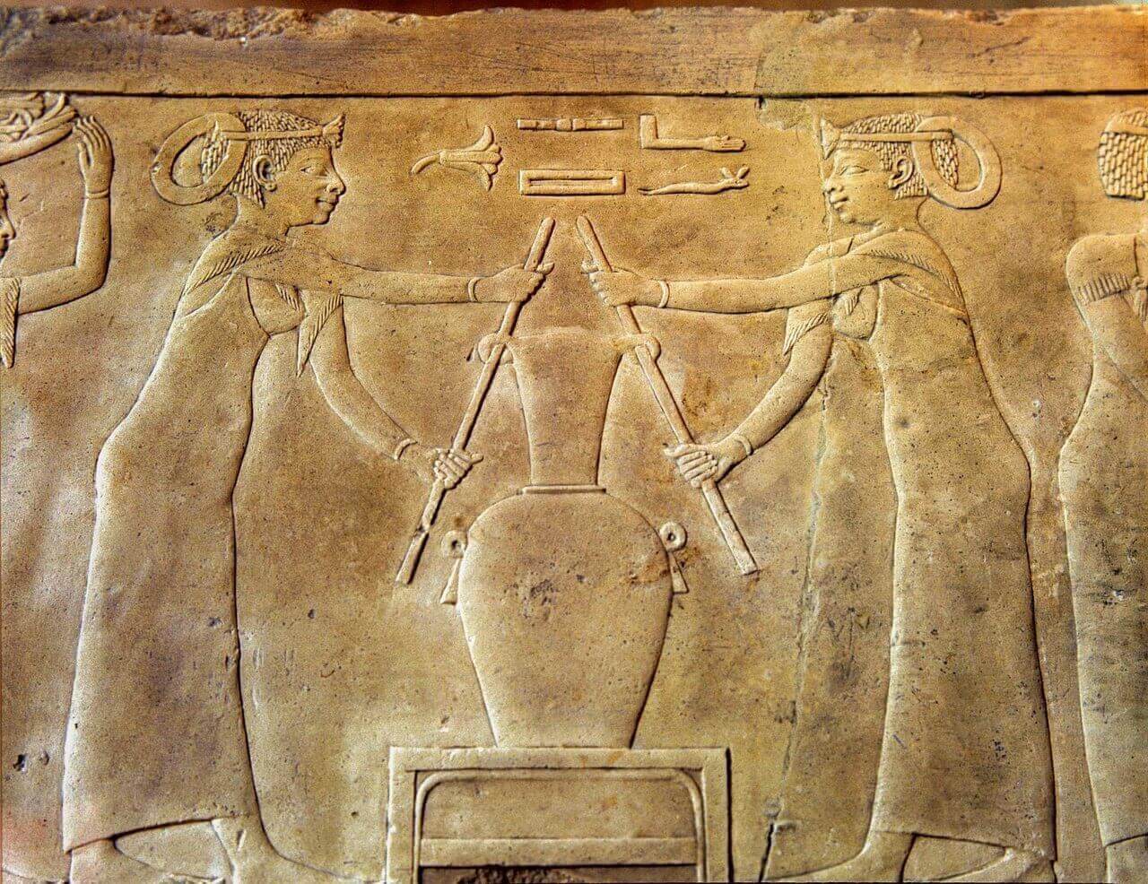 Ancient Egyptian wall relief depicting the preparation of perfume using vessels and ritual implements