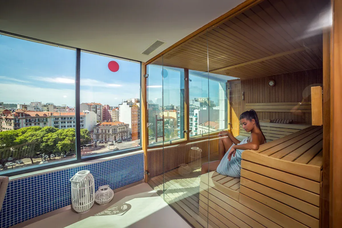 Modern sauna with city views at EVOLUTION Lisboa Hotel — a grounding wellness space to reset your energy for faster manifestation.