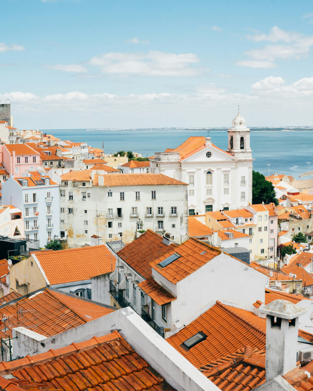 Lisbon pastel rooftops overlooking the Tagus River in soft morning light