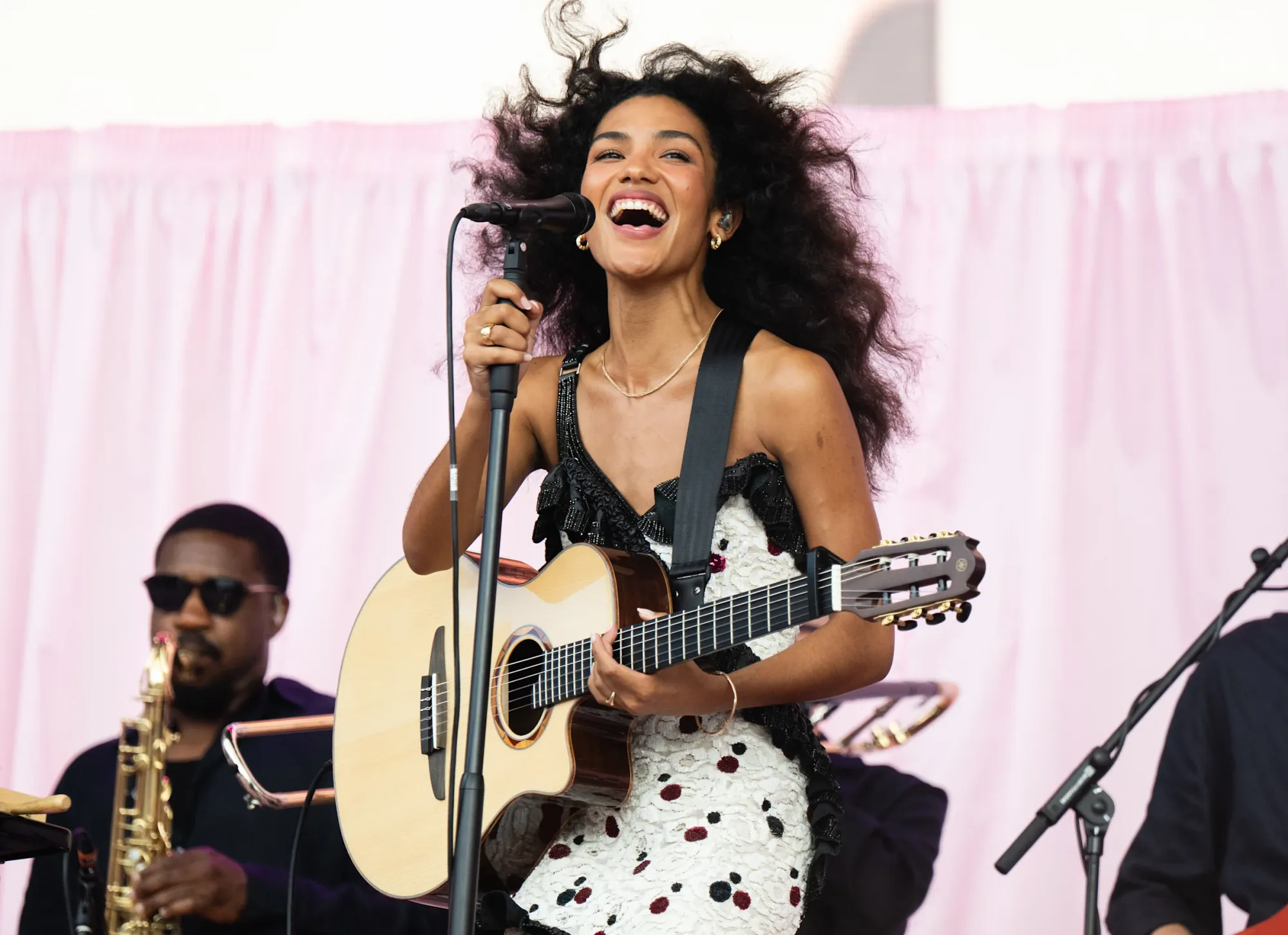 Olivia Dean performing on stage, radiating joy, confidence, and manifestation through embodied self-expression, soulful music, and magnetic presence.