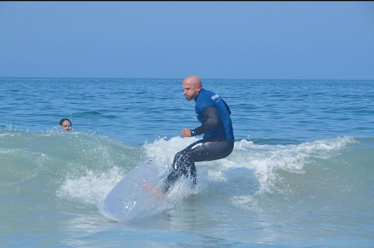 Hector Jesus Arencibia surfing in Portugal, representing the embodied freedom and vitality that comes from living in alignment with manifestation principles
