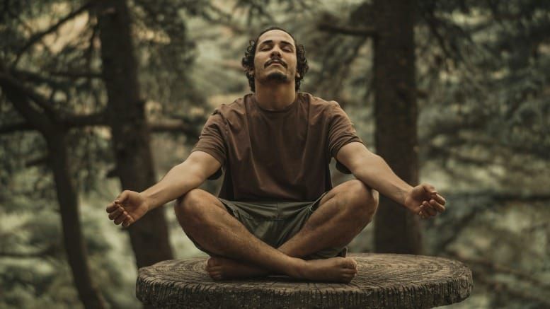 Hombre cerrando los ojos en meditación accediendo al poder de la imaginación según las enseñanzas de Neville Goddard