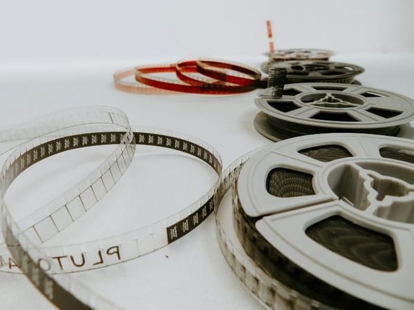 Film reels being edited by hand, symbolizing conscious memory revision as a tool for manifestation and identity transformation.