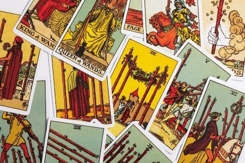 Close-up of a tarot deck on a velvet cloth with The Fool and The Lovers visible.