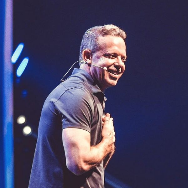 Dr. Joe Dispenza teaching meditation and consciousness reprogramming at live workshop on stage