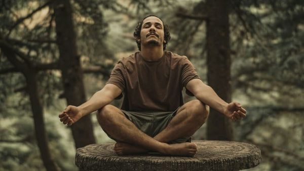 Hombre cerrando los ojos en meditación accediendo al poder de la imaginación según las enseñanzas de Neville Goddard