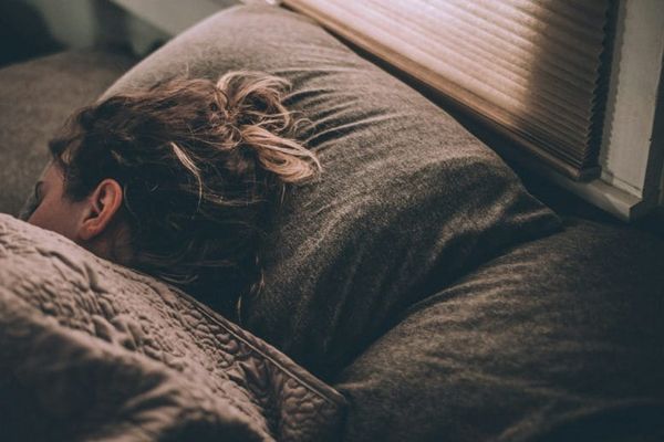 Mujer haciendo SATS de Neville Goddard entrando al estado similar al sueño antes de dormir