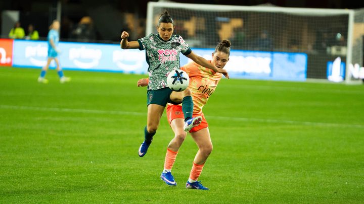 Washington Spirit defender Lucia Di Guglielmo leaps for the ball ahead of Olivia Moultrie of the Portland Thorns.