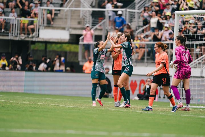 Paige Metayer and Mélissa Bethi celebrate a Washington Spirit goal at Audi Field during a game against Bay FC.