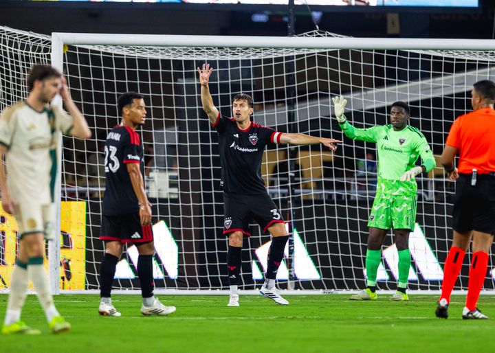 Lucas Bartlett and Sean Johnson gesture to teammates during a game between D.C. United and Atlanta United.