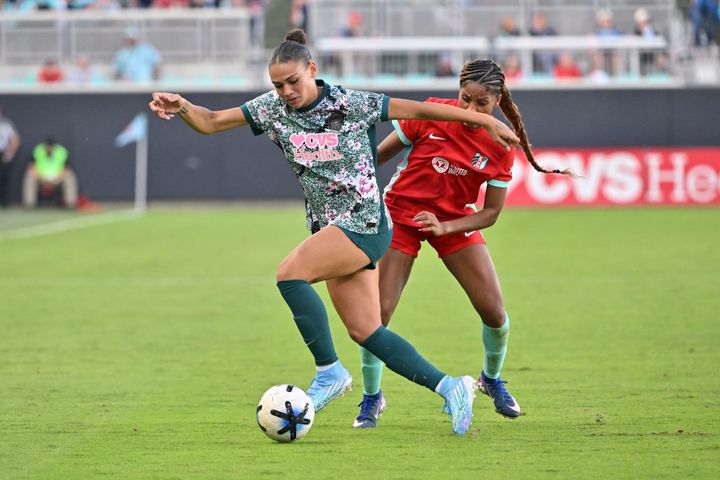 Trinity Rodman dribbles around Laney Rouse during an NWSL game between the Washington Spirit and Kansas City Current.