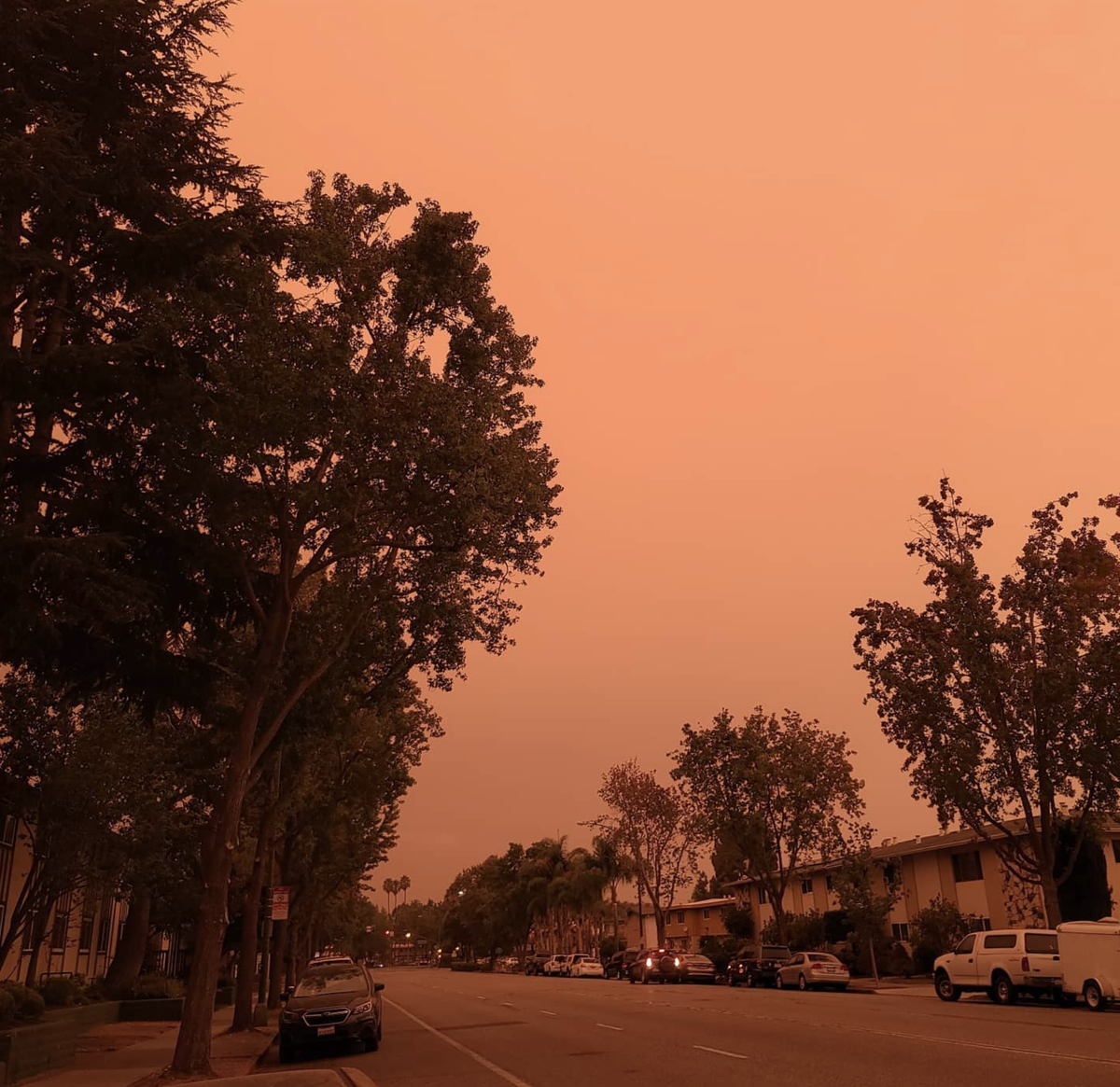 Image of orange-tinted skies over a residential neighborhood due to wildfire smoke.